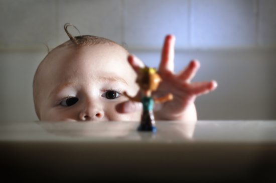 Baby reaches for toy