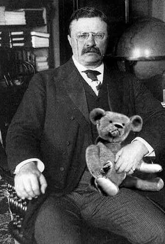 Teddy Roosevelt holds teddy bear on lap