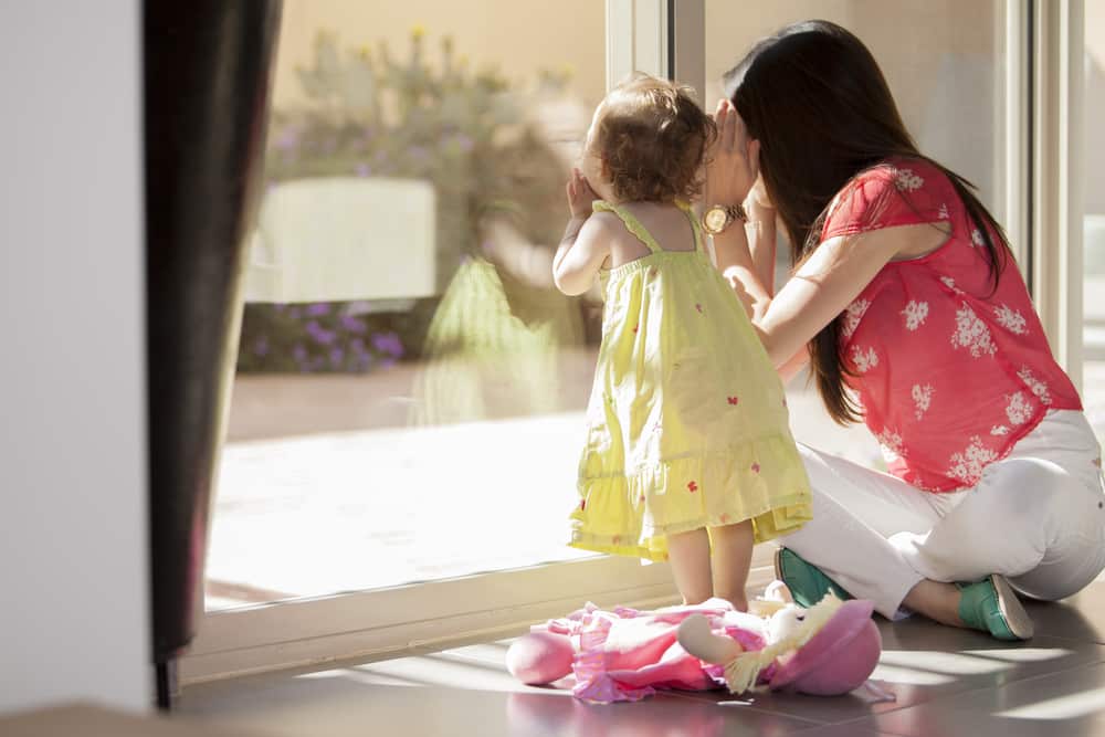 choosing the perfect babysitter, babysitter and toddler peek out window, doll on floor