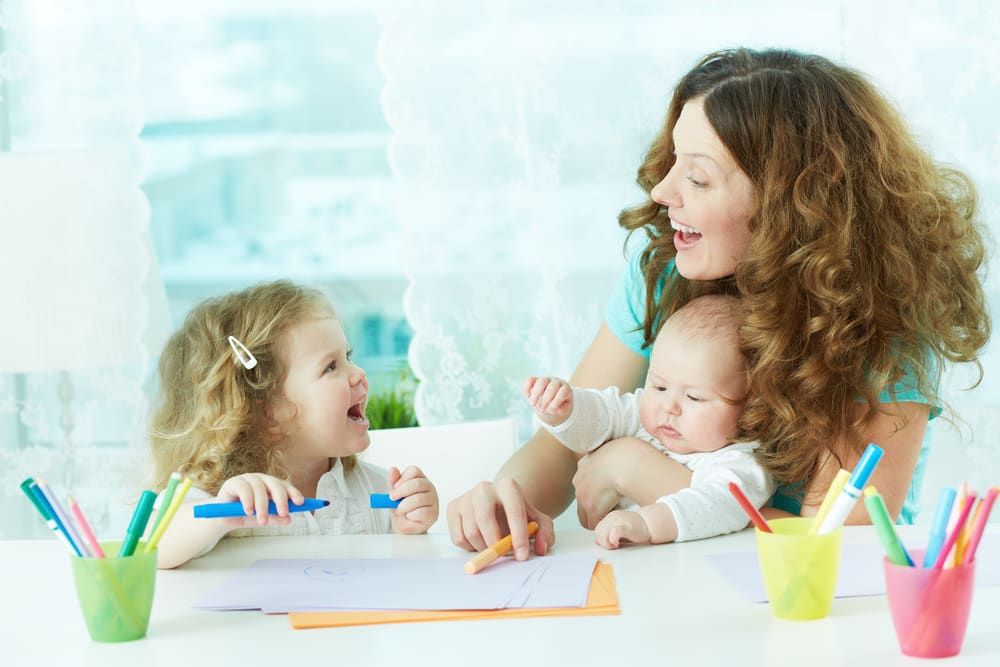 choosing the perfect babysitter, babysitter draws alongside little girl, with infant on lap