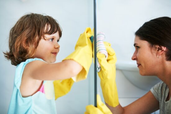 child helps mother clean window