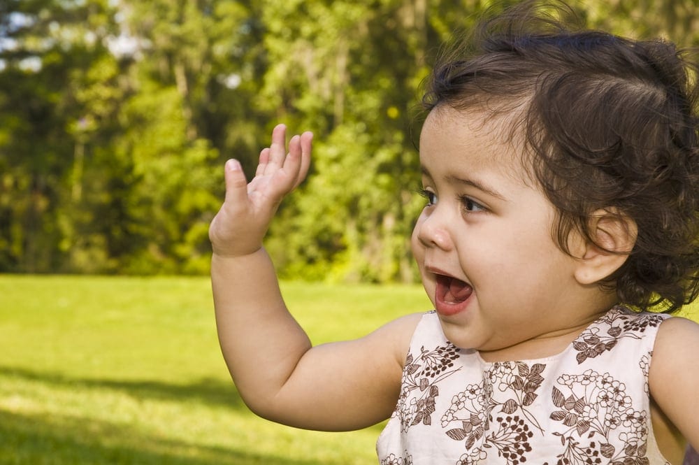 girl toddler waves, green park background