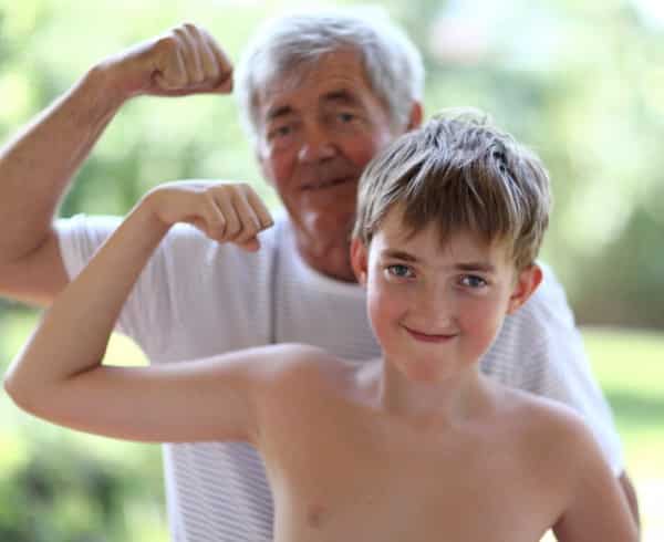 Smiling grandparent and grandchild make fists, illustrates better grandparents build relationships