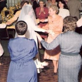 Merle looks on (right in white top, just behind my mom) as my mother and I dance at my wedding. Merle and I were 18.