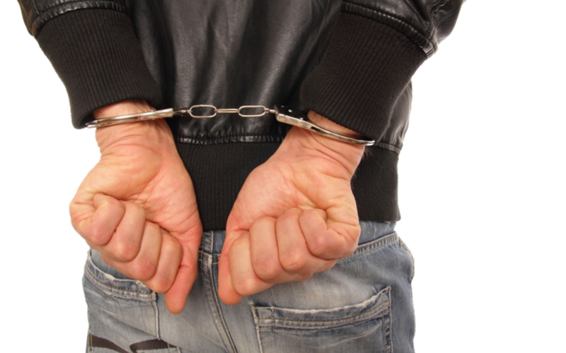 teenage boy in leather jacket handcuffs arrested