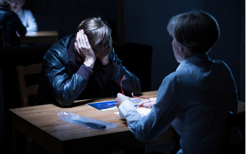 young offender covers ears during interrogation