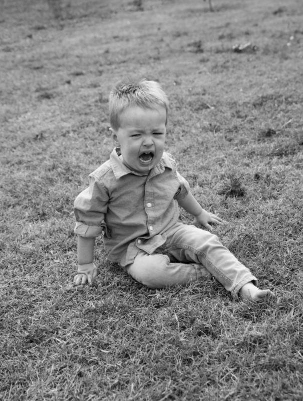 Little boy having tantrum in the grass black and white