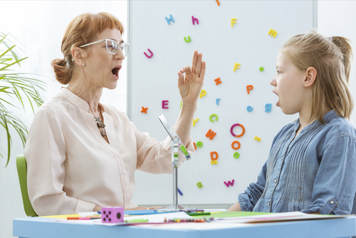 special education teacher works with student on verbal skills