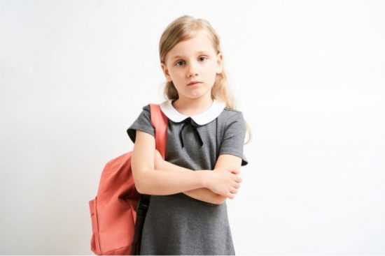 school girl with heavy backpack to illustrate backpack safety concepts