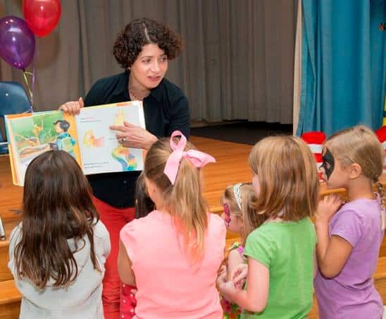 A TRC volunteer reads aloud to spellbound children.