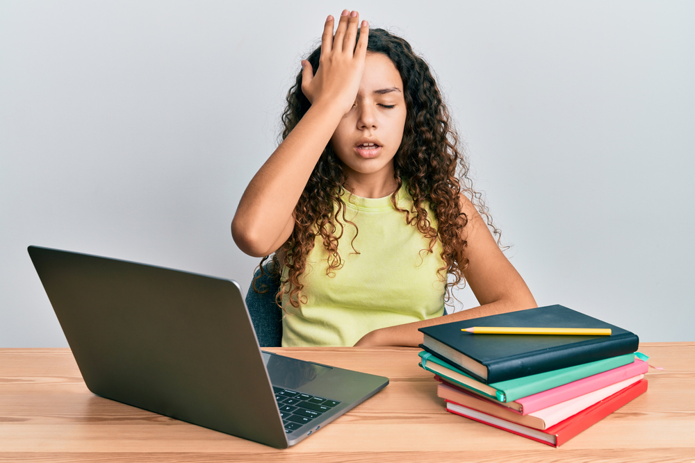 Teenager,Hispanic,Girl,Sitting,On,The,Table,Studying,For,School