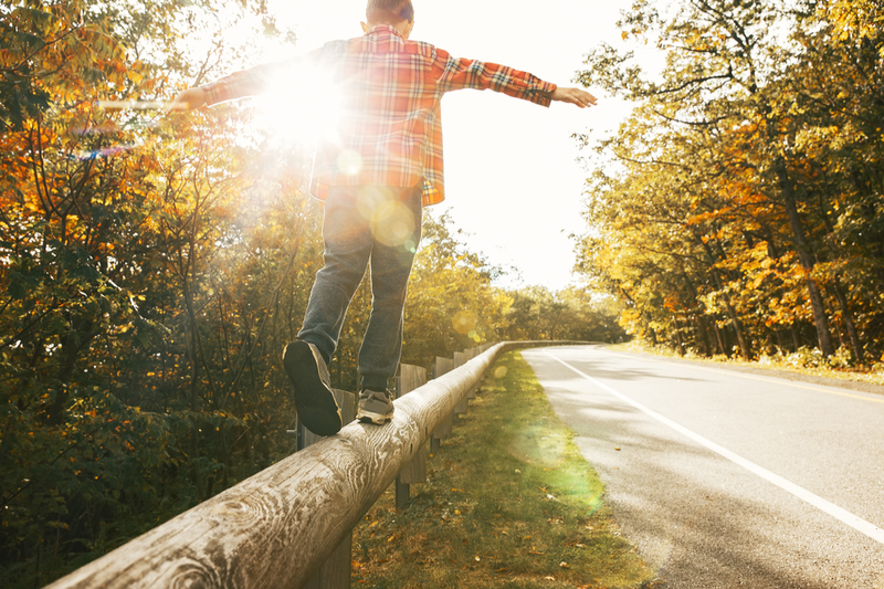 teen balances and walks on railing