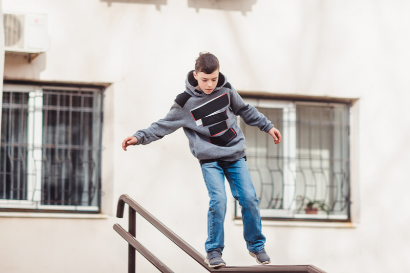 teen walks on railing