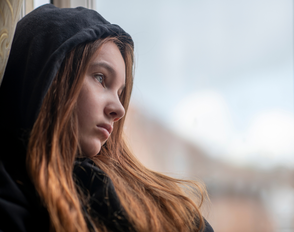 Low,Angle,Sad,Teen,Girl,In,Black,Hoodie,Resting,Near