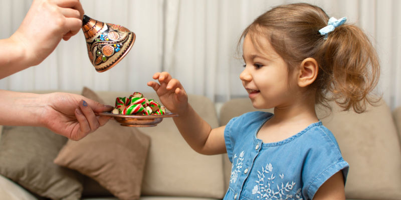 Little girl chooses candy from dish