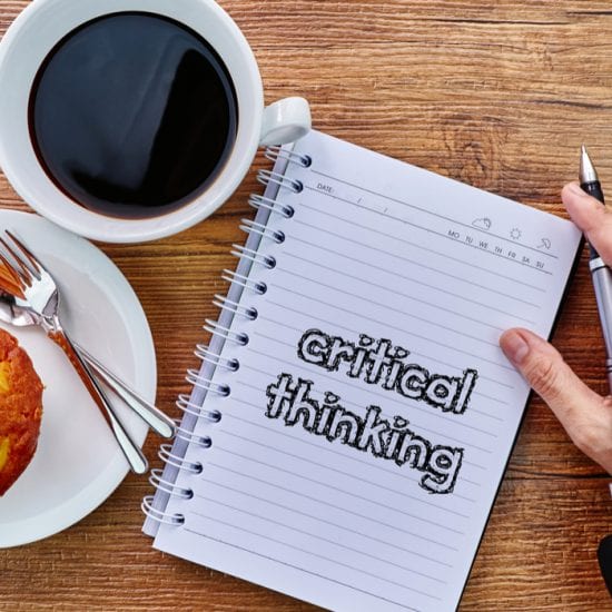 cup of coffee and danish next to hand writing on a notepad "critical thinking"