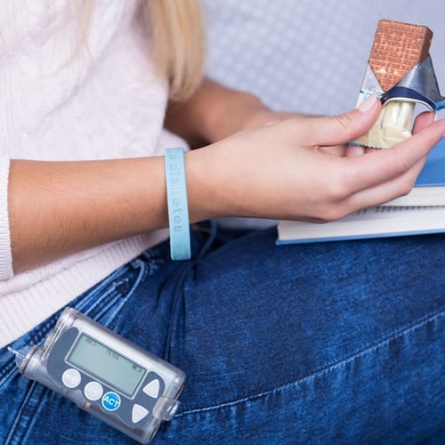 Diabetic teen with insulin pump eating source of glucose