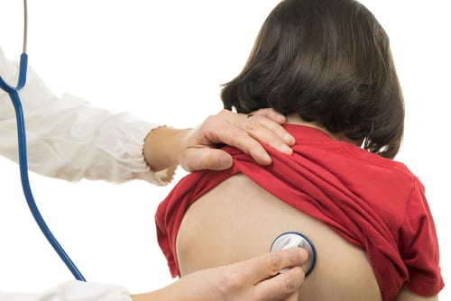 Doctor applies stethoscope to child's back.