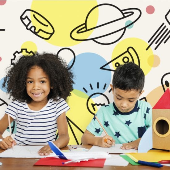 How Does the Brain Learn: A smiling black girl next to Hispanic boy, both doing schoolwork