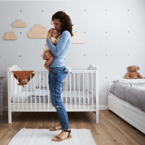 Mother enjoys close contact with her infant, in the baby's bedroom