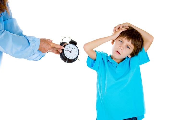 Mother showing tired boy with ADHD symptoms that it's time to go to bed