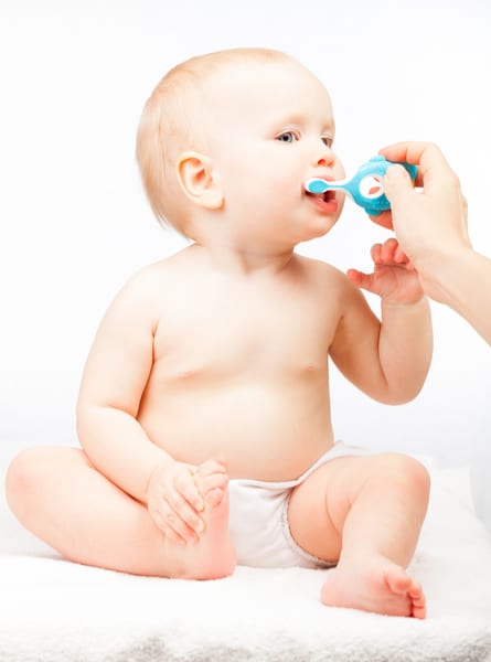 Infant has his teeth brushed