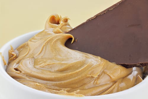 Chocolate being dipped into peanut butter