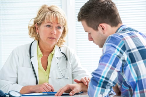 Sympathetic mental health professional listens to teenage boy