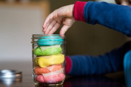 Child chooses from colorful stack of homemade playdough