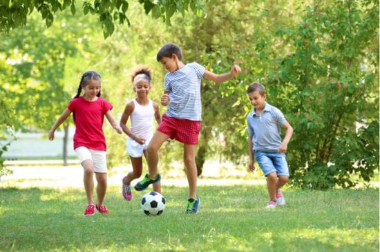 Kids Playing Soccer Outside in the backyard