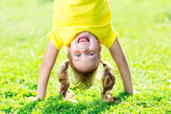 Little Girl does handstand in backyard