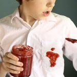 Red jam spill on boy's white shirt