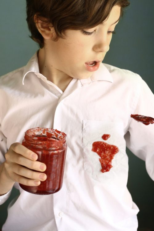 Red jam spill on boy's white shirt