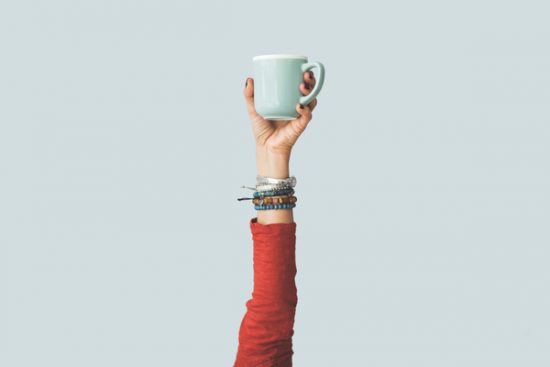 Arm holding up coffee cup