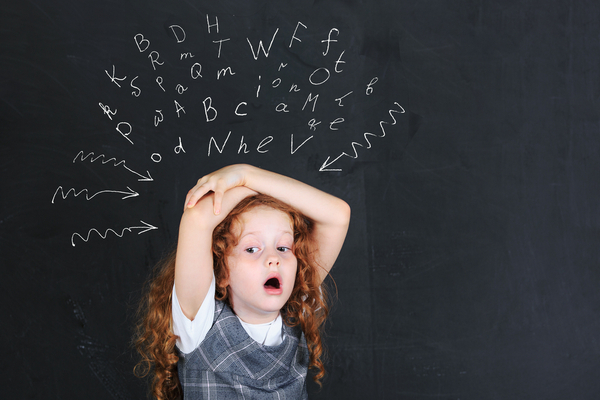 Girl with dysgraphia thinking letters