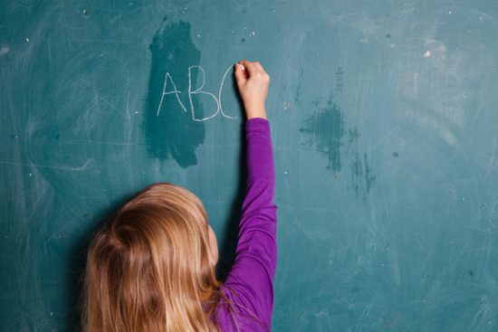 Girl writing on chalkboard