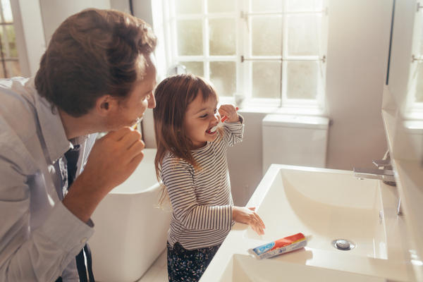 Father and daughter brush teeth