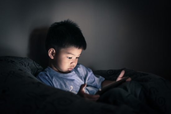 Small Asian boy using iPad