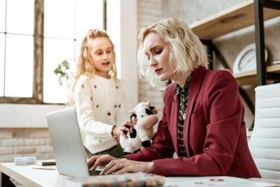 Kids interrupt: Girl distracts mom from computer with plush cow