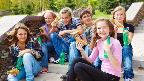 happy teens eat junk food drink soda