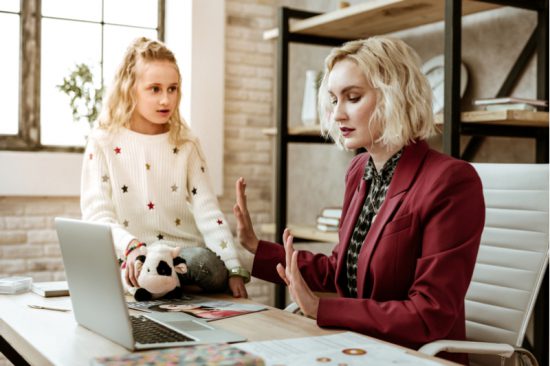 Kids interrupt as does this girl whose mother holds up hands as daughter tries to distract her