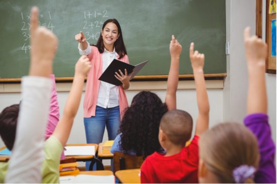 smiling teacher eager students raise hands