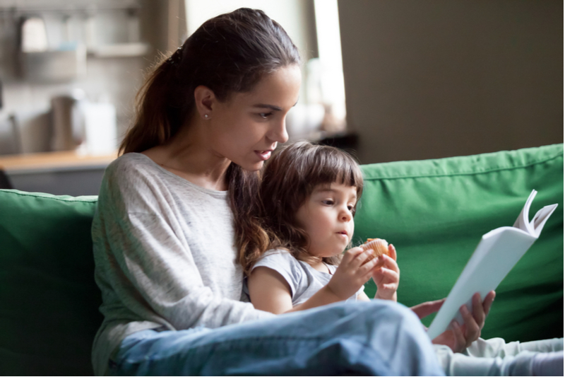 Babysitter reads storybook to young girl