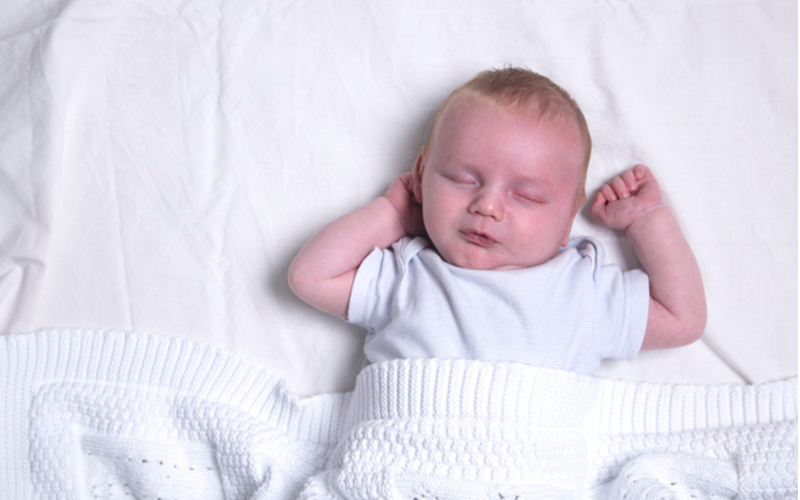 Baby asleep on back in crib