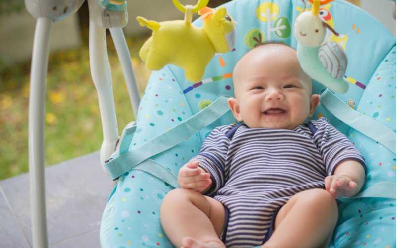 smiling asian baby in bounce seat