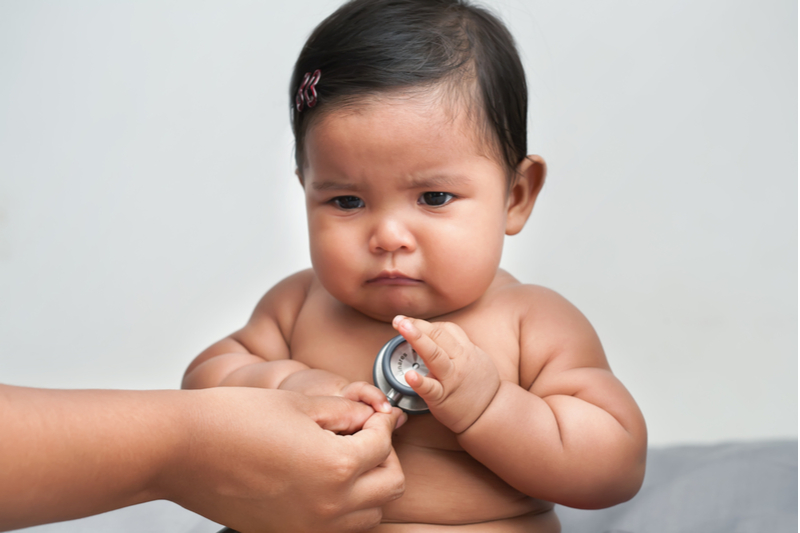 Fat unhappy baby receives checkup