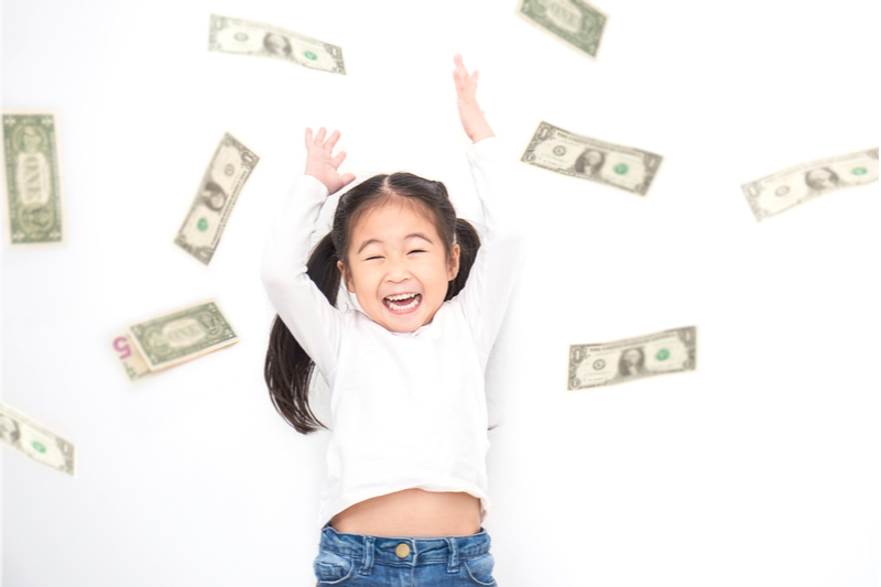 Happy pigtailed Asian girl throws money in air