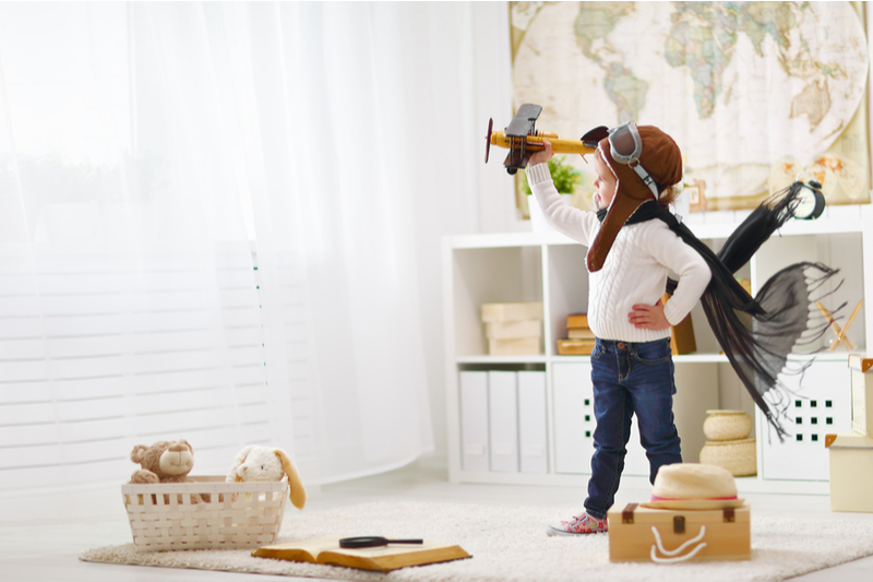 little boy plays pilot in bedroom