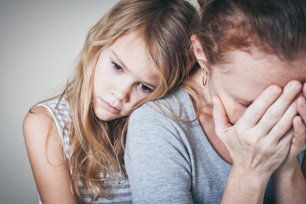 Girl comforts worried mother