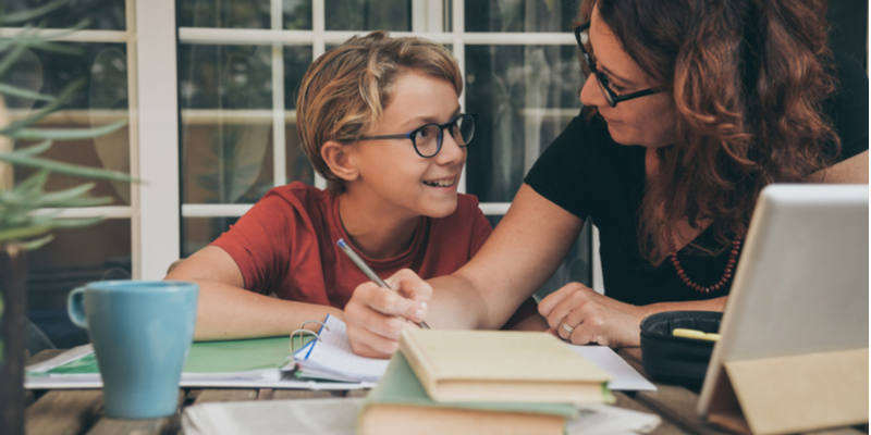 Mother smiles at son during coronavirus homeschooling session